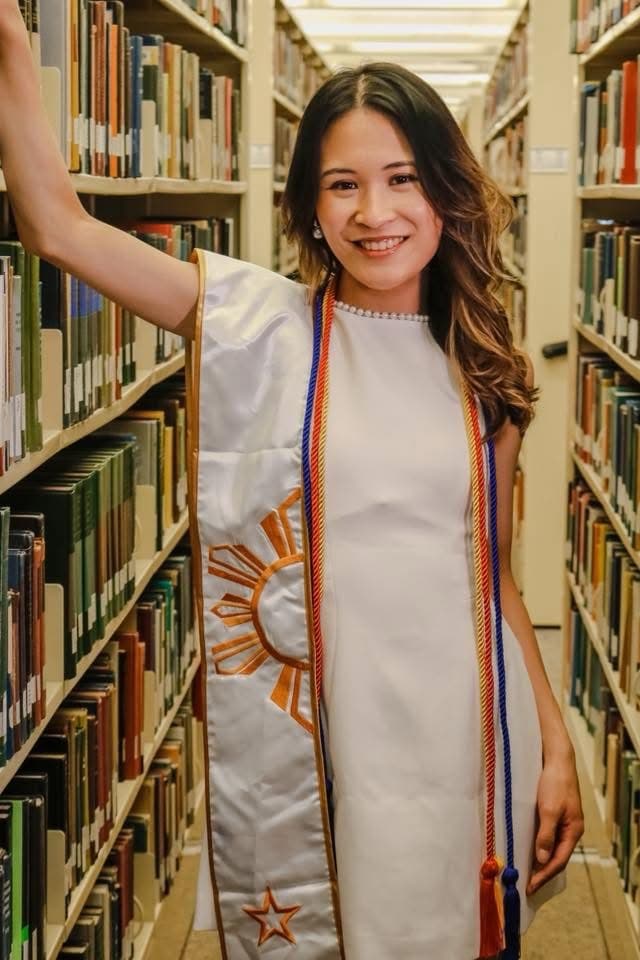 Ysabella Uy in her graduation dress with a Philippine sun stole, in the UTRGV library